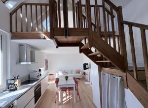 a kitchen and dining room with a wooden staircase at Location Maison Larmor plage in Larmor-Plage