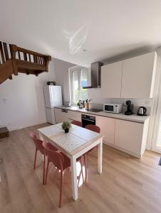 a kitchen with a table and chairs in a room at Location Maison Larmor plage in Larmor-Plage