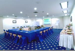 a conference room with a blue table and chairs at Surabaya Suites Hotel Powered by Archipelago in Surabaya +37 photos
