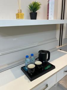 a tray with a coffee maker and water bottles on a counter at غرفه وصاله قريبه من المطار in Jeddah