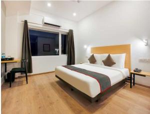 une chambre d'hôtel avec un grand lit et une fenêtre dans l'établissement Townhouse Rajahmundry City Centre Formerly Svas Inn, à Godāvari