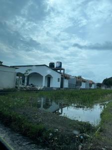 a white building with a reflection in a field at Villa sawah yogyakarta in Godean