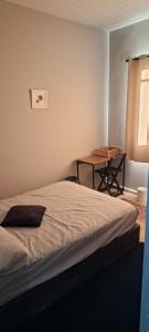 ein Schlafzimmer mit einem Bett und einem Tisch mit einem Fenster in der Unterkunft Pequeno quarto no coração de Curitiba in Curitiba