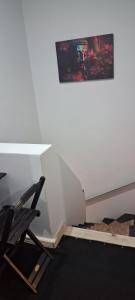 einem Stuhl vor einer weißen Wand in der Unterkunft Pequeno quarto no coração de Curitiba in Curitiba