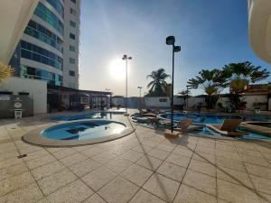 ein großes Schwimmbad mit Stühlen und einem Gebäude in der Unterkunft Flat - Fiore Prime Flat Style - 5 pessoas - Apartamento - 5 andar in Caldas Novas