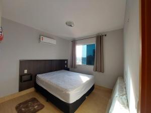 ein kleines Schlafzimmer mit einem Bett und einem Fenster in der Unterkunft Flat - Fiore Prime Flat Style - 5 pessoas - Apartamento - 5 andar in Caldas Novas + 9 Fotos