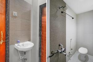 Un baño con lavabo, inodoro y ducha. en Hotel O Sai Teerth Theme Park Formerly Sai Dhanlaxmi, en Shirdi