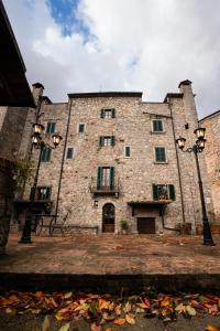 a large stone building with two street lights at Historic Farmhouse Casa Del Chiodo in Torniella