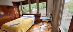 a bedroom with a bed and a table and a window at Recanto da Morgana-Lofts bem equipados, conforto e piscina grande in Teresópolis
