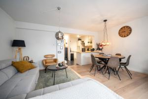 een woonkamer met een bank en een tafel bij JoLi Beach Apartment in Middelkerke