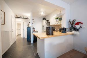 een keuken met witte muren en een houten aanrechtblad bij JoLi Beach Apartment in Middelkerke