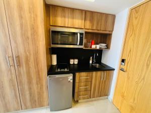 a kitchen with a small refrigerator and a microwave at Life Bucerías, Modern Studio Near the Beach in Bucerías