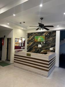 a lobby with a counter with a ceiling fan at Ganga villa in Jāmb