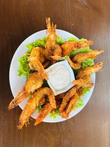 a plate of shrimp and lettuce with dipping sauce at Hotel y Restaurante Playa Dorada in Monterrico