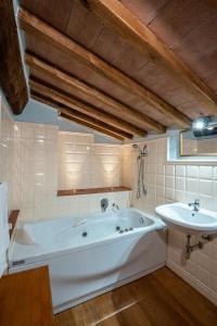 a bathroom with a large tub and a sink at Historic Farmhouse Casa Del Chiodo in Torniella