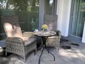 - deux chaises et une table sur une terrasse couverte dans l'établissement Ferienwohnung Seeperle, à Bad Zwischenahn 25 autres photos