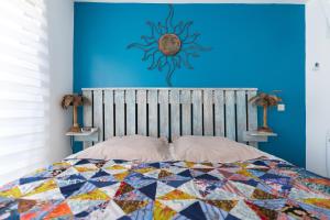 une chambre avec un lit avec un mur bleu dans l'établissement Grand T2 ensoleillé, à La Grande Motte