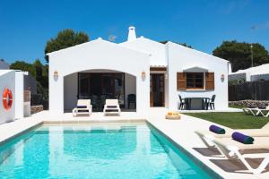 una villa con piscina frente a una casa en Garbo by Vintage Travel, en Cala Morell