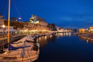 Un grupo de barcos atracados en un puerto deportivo por la noche. en Garbo by Vintage Travel, en Cala Morell