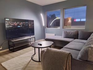 a living room with a couch and a flat screen tv at Appartement in Harstad 2 in Harstad +5 photos