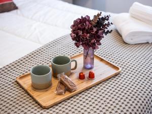 a tray with two cups and a vase with flowers and cookies at Gaston Lejeune tweede in Galopen
