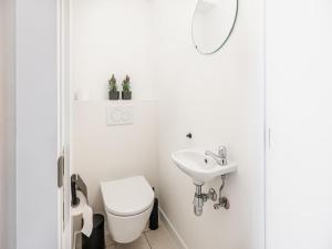 a white bathroom with a toilet and a sink at Gaston Lejeune tweede in Galopen +14 photos