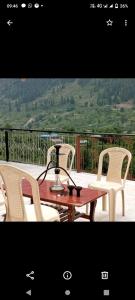 two chairs and a table with a lamp on a balcony at Hotel classic kuppa sangla in Sāngla