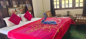 a bedroom with a bed with a peacock on it at Hotel classic kuppa sangla in Sāngla +14 photos