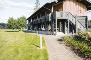a large wooden building with a porch and a walkway at Toosikannu Nature Resort & Hotel in Käru +49 photos