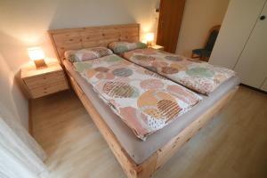 two beds in a bedroom with two lamps on a floor at Chalet Christina 7 in Arosa