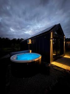 a large blue tub sitting next to a building at Holiday Hill Karpnki, Domki z sauną, balią i jacuzzi na wyłączność in Karpniki