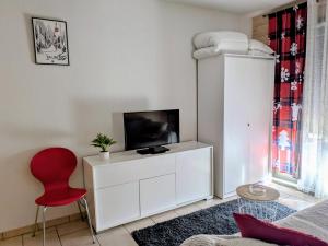 a living room with a tv and a red chair at Cosy Suite chalet in Valloire