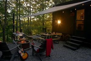 a cabin with a table and chairs and a guitar at Postcard Cabins Piney Woods, Outdoor Collection by Marriott Bonvoy in Coffee City