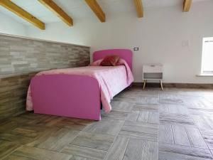 a bedroom with a purple bed and a wooden floor at La Chioma di Berenice in Celano