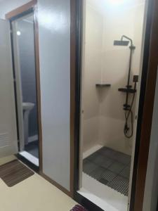 a bathroom with a shower with a glass door at Tony's City Centered Budget Room in San Fernando