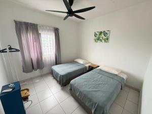 a bedroom with two beds and a ceiling fan at Metia residence in Shah Alam