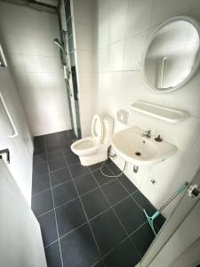 a bathroom with a toilet and a sink and a mirror at Metia residence in Shah Alam