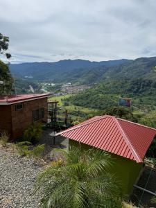 a house with a red roof and a view of a valley at Cabaña vista al vall in Paraíso