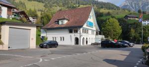 a large white house with cars parked in a parking lot at Fischers Fritz in Innerthal
