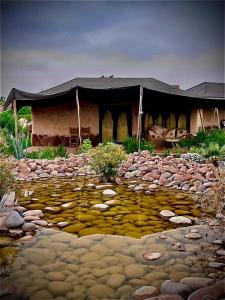 a house with a stone path in front of a building at Les Bedouins Agafay in Oulad Akkou