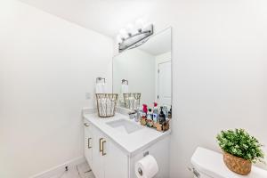 a white bathroom with a sink and a mirror at KimzNest in Edmonton +8 photos