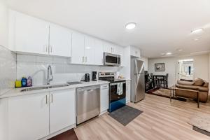 a kitchen with white cabinets and a living room at KimzNest in Edmonton