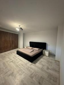 een slaapkamer met een bed en een houten vloer bij Madona Apartment in Craiova