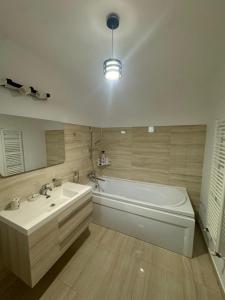een badkamer met een bad, een wastafel, een bad en een bad bij Madona Apartment in Craiova