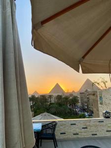 a view of the pyramids from a patio with an umbrella at Velora Pyramids Hotel in Cairo