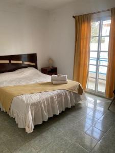ein Schlafzimmer mit einem Bett und einem großen Fenster in der Unterkunft Complejo Gago DTO 1 in Puerto Madryn
