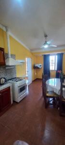 a kitchen with a stove and a table in a room at Alojamiento la posta in Perico