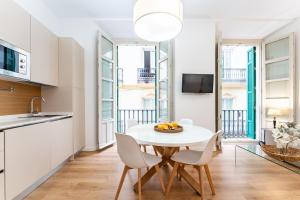 a kitchen and dining room with a white table and chairs at Apartamento Centro Histórico I in Málaga