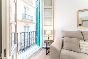 a living room with a couch and a large window at Apartamento Centro Histórico I in Málaga +20 photos
