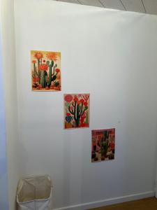 four paintings hanging on a white wall at La Pistacherie à 30m de la plage de Grande Rive in Évian-les-Bains +30 photos